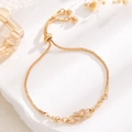 Adjustable gold heart and infinity bracelet with sparkling crystals on stone background - Heart Infinity Style