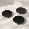 Three minimalist black metal candle trays with spherical feet on a stone surface - 3-Piece Round Tray Set / Black