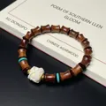 Bamboo-shaped ebony wood bracelet with white floral bead and turquoise accents - 7x8mm Bamboo Joint Awakening Lion