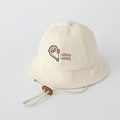 Detailed view of cream baby bucket hat featuring cute otter embroidery and chin strap - 48cm (5-18 Months) / Off-white