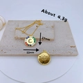 Detail of gold pendants with CZ inlay and enamel moon motif against a textured stone backdrop - Colorful Enamel Moon Star