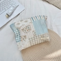 Dettaglio della borsa da trucco trapuntata a fiori con pizzo ed etichetta logo - Patchwork a Quadretti Blu