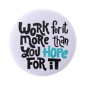 Round white tinplate badge featuring artistic motivational black and teal typography - WORK for it MORE