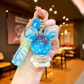 Detail of creative liquid quicksand keychain featuring blue stars and Bubble rubber strap - Blue Sitting Bear with Gradient Rope