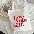White canvas tote bag featuring red love yourself printed text on white fabric - Red Slogan Love Yourself