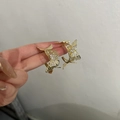 Elegant gold butterfly hoop earrings with white rhinestones on hand for size - Gold Rhinestone Butterfly Hoop
