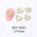 Makrofoto eines 11x10mm Herz-Nagelcharms mit grünem Opal und Gold-Strass-Rand - Hellgrünes Herz mit goldenem Rahmen (9203)