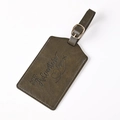 Close-up of olive green PU leather luggage tag with Adventure Begins embossed text - Khaki