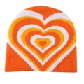 Detailed knit texture of orange and yellow heart pattern beanie with white accents - Orange