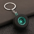 Macro detail of PVC tire keychain with cyan metal rim and textured rubber tread - Green