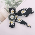 Detail of floral ribbon watch band featuring white daisies and a silver round dial - Silver Case Black Dial