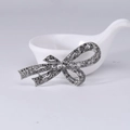 Broche nœud argentée avec pierres marcassites gris foncé et design filigrane ajouré - Argent antique avec strass gris foncé