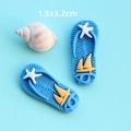Dettaglio di accessori infradito in resina blu con stella marina e barca per il fai da te - Pantofola Blu
