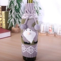 Knitted Christmas wine bottle cover with purple gnome pattern and plush pom-poms - Gray