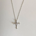 Macro view of silver cross necklace featuring brilliant white cubic zirconia stones - Silver