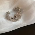 Vue détaillée du bracelet jonc argenté avec motifs ajourés de fleurs et de feuilles - Argent