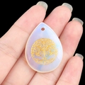 Opalite teardrop pendant featuring a golden tree of life engraving on a milky surface - Opal (Synthetic)
