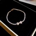 Close-up of sparkling bow-shaped zircon bracelet displayed in a premium black gift box - Gold