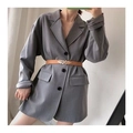 Détail d'une ceinture marron avec boucle feuille sur un blazer gris pour un look chic - Camel