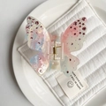 Detail shot of a gradient butterfly hair clip with pink rhinestones and a gold spring - Blue-Pink Gradient