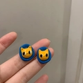 Close-up of yellow 3D cat stud earrings with navy blue resin oval borders - 27# Silver Earring Post - Blue Frame Yellow Cat Studs