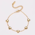 Detalle de pulsera de acero inoxidable dorado con dije de corazón sobre fondo blanco - Dorado