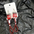 Macro detail of creative blood bag earrings with red liquid and AB blood type label - Type AB Stud Earrings