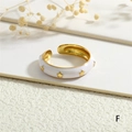 Detail of white enamel open ring with gold star patterns and 18K gold plated interior - White