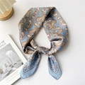 Light blue paisley silk scarf with sun and star motifs tied in a stylish knot - Blue Sun Butterfly Paisley