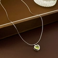 Gedetailleerd beeld van een groene hartvormige zirkoon hanger aan een zilveren schakelketting - Zilveren Zirkonia Hart