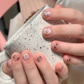 Close-up of pink cat-themed press-on nails with paw prints on a ceramic mug - By1562 Cat Says Nine Principles / Glue Type