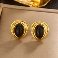Close-up of vintage heart-shaped gold studs with black resin inlay on textured surface - 18K Gold/Black Resin / Gold/Black