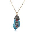 Macro detail of natural blue crystal pendant with multi-color stones on gold chain - Blue