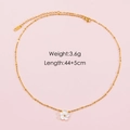 Détail d'un collier en acier inoxydable doré avec pendentif fleur en nacre - Doré
