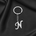 Polished stainless steel letter N keychain pendant on an elegant dark silk background - Letter N