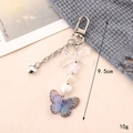 Detalle de llavero de lazo acrílico con mariposa degradada y cuentas de corazón, 9,5 cm - Colgante de Mariposa de Acrílico Gris Negro