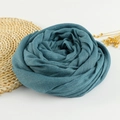 Close-up of lake blue cotton linen scarf folded as rose with fringe edges and dried flowers - 190x100cm / Teal Blue
