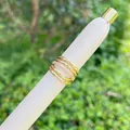Makro-Detail von geschichteten 18K vergoldeten Mesh-Ringen mit funkelnden Zirkonia-Steinen - Filigranes Mehrring Pave Modell