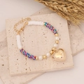 Detailed shot of Bohemian beaded bracelet with gold heart charm and colorful clay discs - Camouflage (5#)
