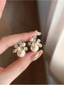 Primer plano de pendientes de flores bañados en oro 18k con perlas y circonitas - Base Dorada Perla Blanca