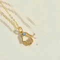 Nahaufnahme der goldenen Hand der Fatima mit blauem Auge und Zirkonia-Besatz - Hohl Fatima Hand Anhänger