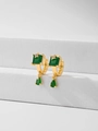 Macro detail of gold earrings with square and teardrop emerald green zircons - Green