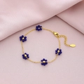 Detailed view of gold steel bracelet featuring five deep blue crystal flower charms - Blue