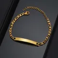 Macro shot of gold plated Figaro ID bracelet featuring a curved engraving plate on black background - 1:3 NK Chain / Gold