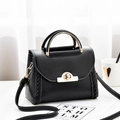 Fashionable black faux leather handbag with gold metal handle and woven side details - Black