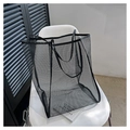 Detail of black mesh tote bag with reinforced handles resting on a white chair - Black