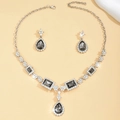 Detailed view of silver necklace and teardrop earring set with grey stones and crystals - Gray