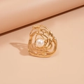 Macro shot of gold irregular spiral open ring with a central white imitation pearl - Gold