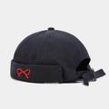 Close-up of navy canvas docker hat featuring red bow embroidery and adjustable metal buckle - Dark Gray