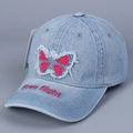 Detail der rosa Schmetterlingsstickerei und Free Flight Schriftzug auf blauer Denim-Kappe - Hellblau / M (56-58cm)